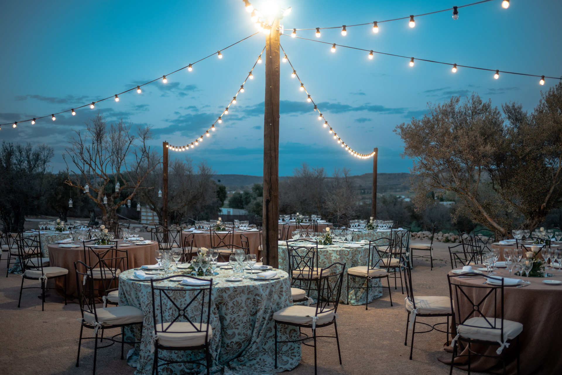 Montaje de mesas nocturno en finca de bodas campo y olivo